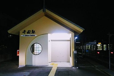 夜の千国駅と背後に電車が