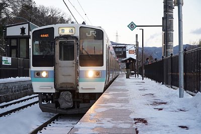 相対式ホームと跨線橋と211系電車